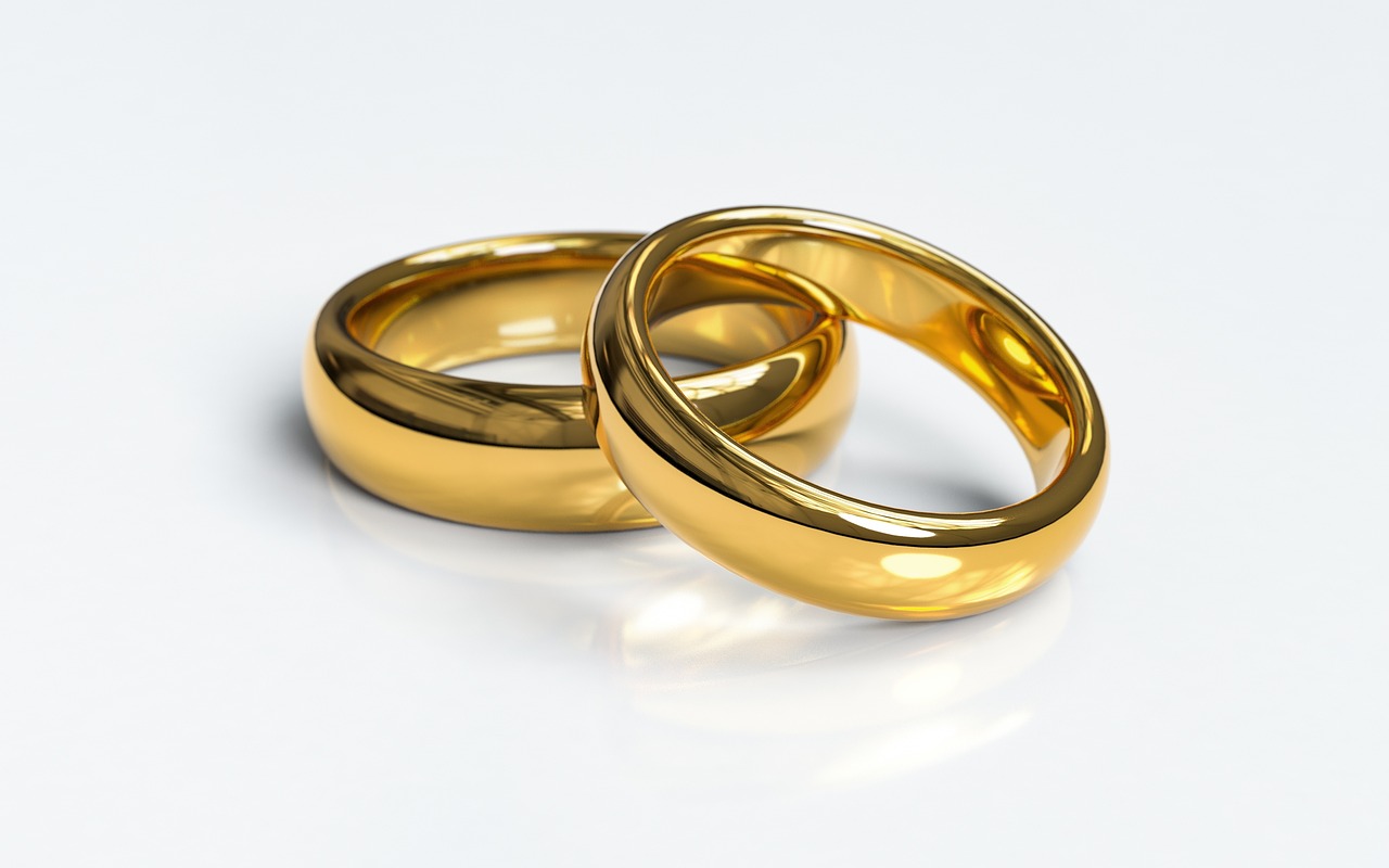 two wedding rings on a white glossy surface